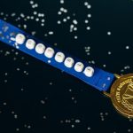 Close-up of a gold medal on a blue ribbon with 'possible' beading, symbolizing achievement.
